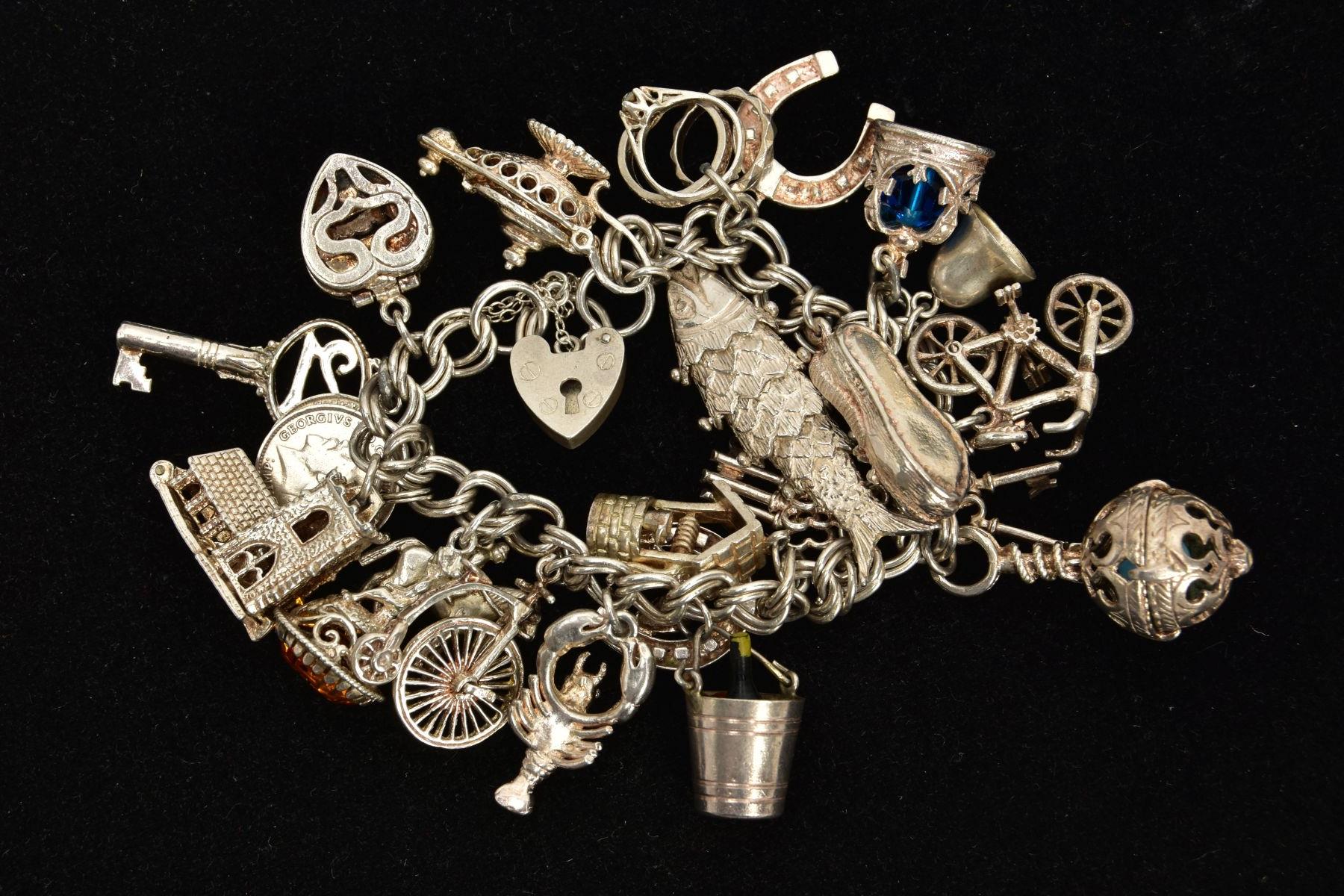 A WHITE METAL CHARM BRACELET, comprising approximately twenty plus various charms to include a fish, - Bild 2 aus 2