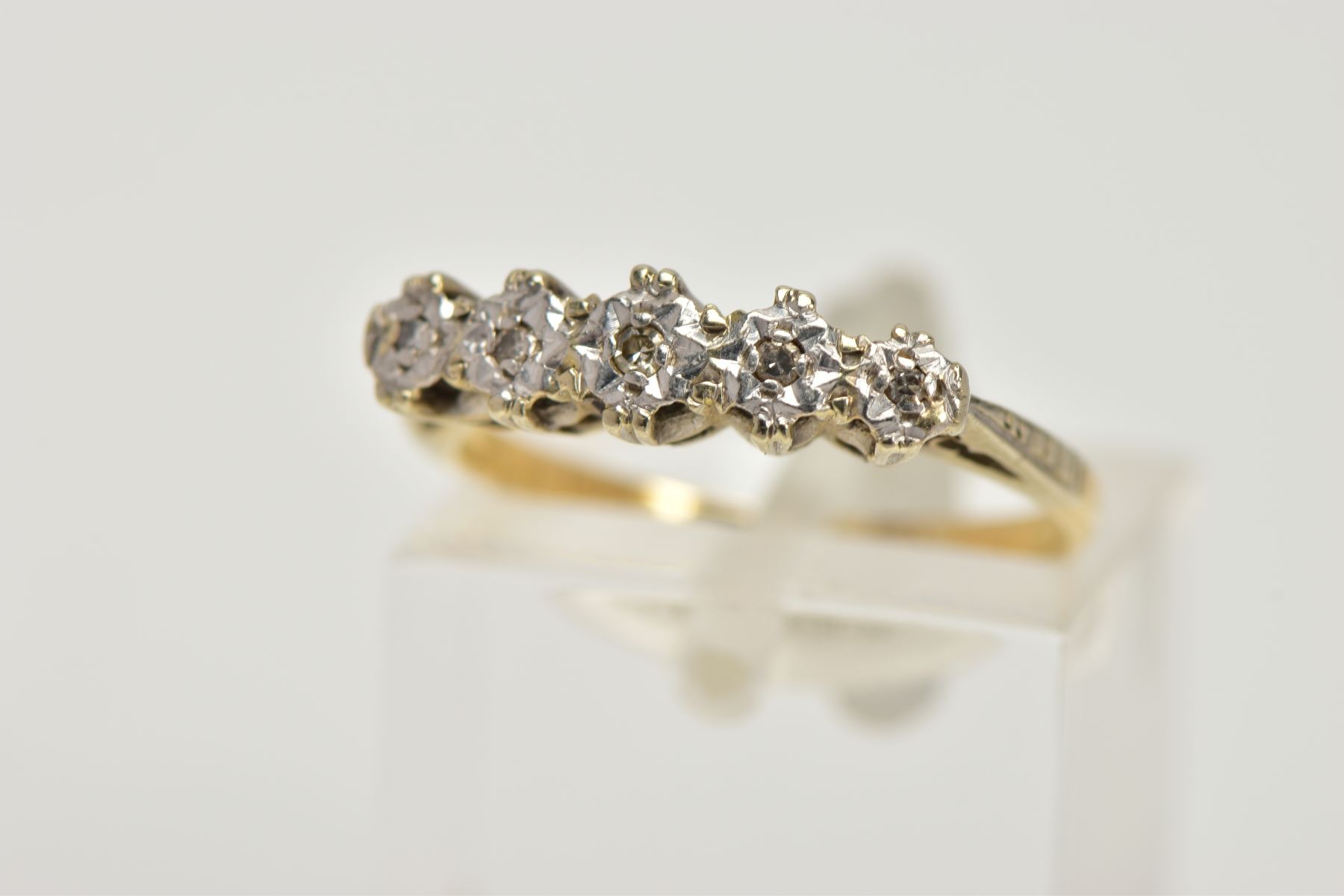 A YELLOW METAL DIAMOND HALF ETERNITY RING, designed with a row of five illusion set single cut