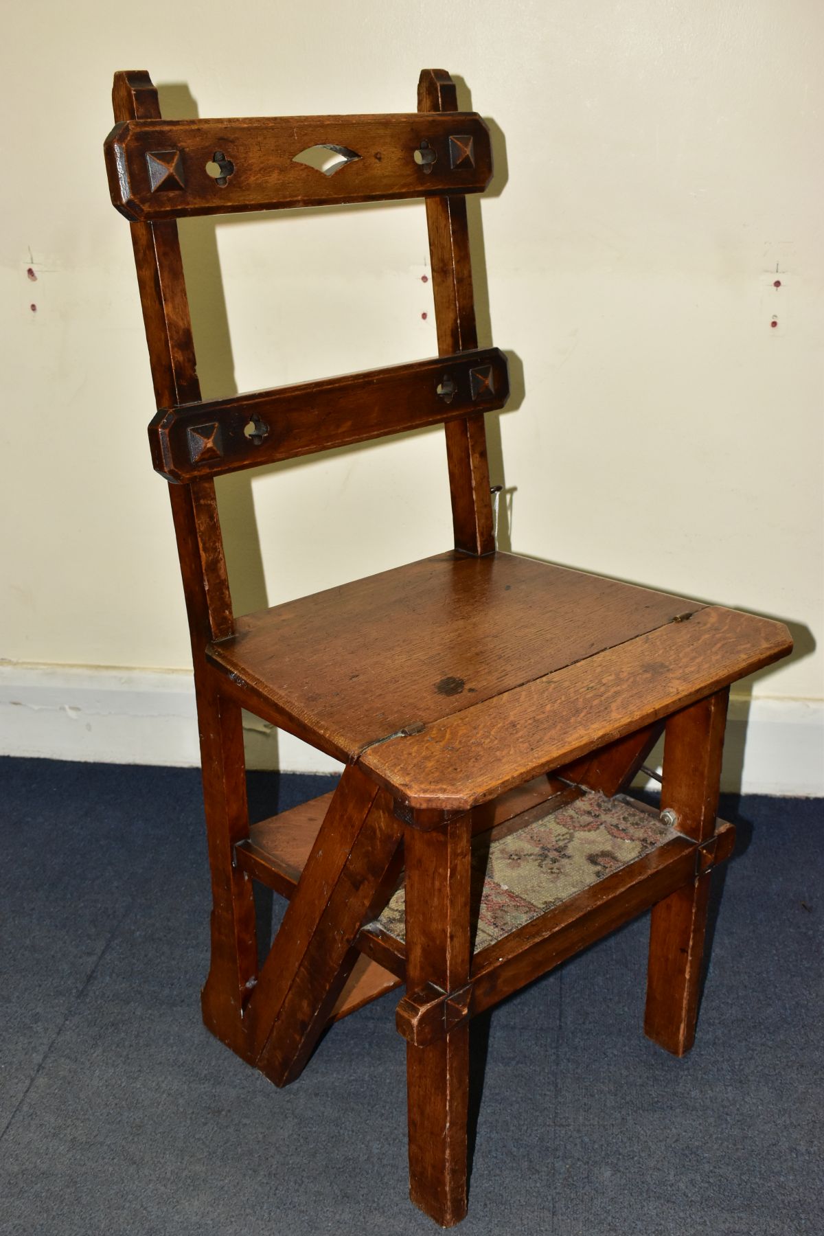 A VICTORIAN OAK GOTHIC STYLE METAMORPHIC CHAIR/LIBRARY STEPS, with quatrefoils to the bar back,