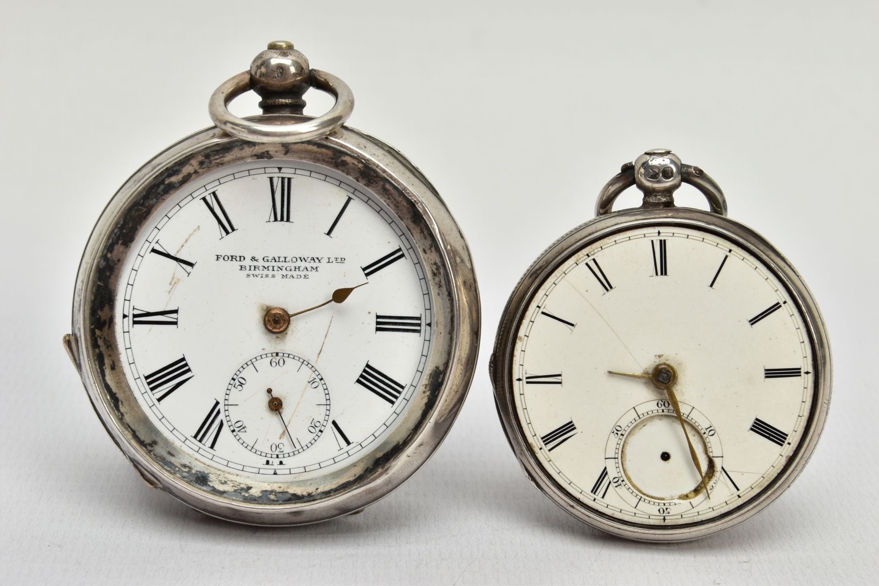 TWO SILVER POCKET WATCHES, the first with an open face, circular white dial, Roman numerals,