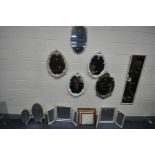 A LARGE QUANTITY OF MIRRORS, comprising a pair of white painted oval French style wall mirrors, a