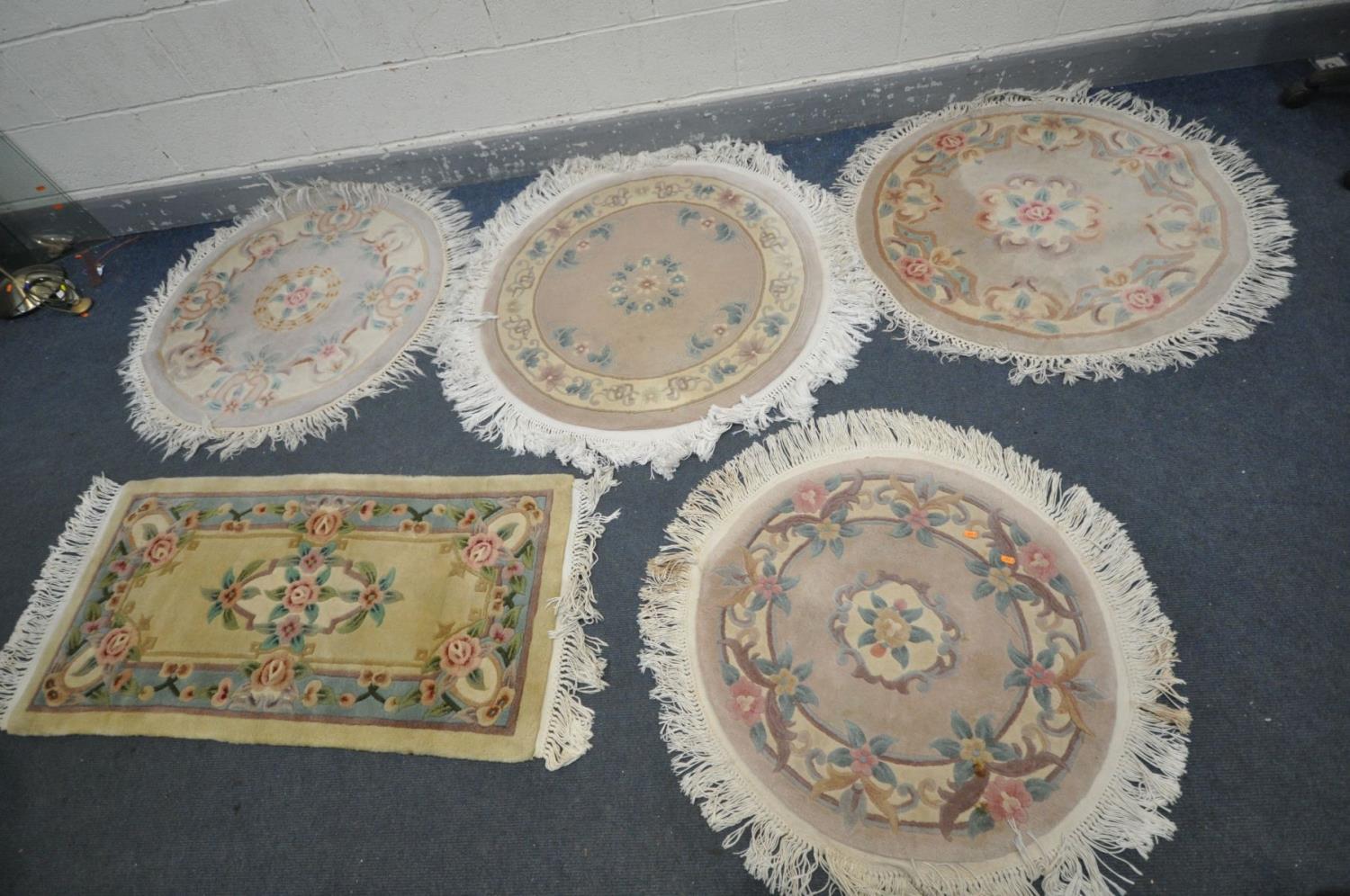 FOUR CIRCULAR WOOLEN RUGS, all various patterns and a rectangular woollen rug (condition - in need