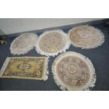 FOUR CIRCULAR WOOLEN RUGS, all various patterns and a rectangular woollen rug (condition - in need