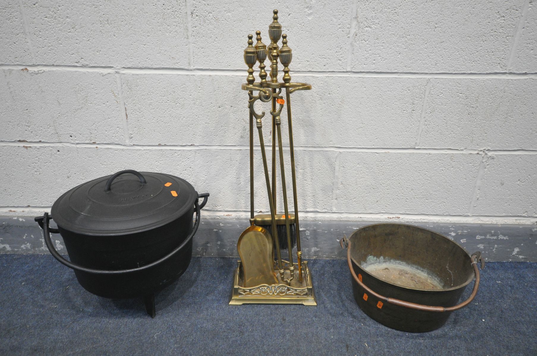 A BRASS FOUR PIECE COMPANION SET, with stand, along with a chappee cast iron cauldron, a brass jam