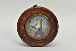 A WOODEN PORTRAIT MINIATURE, depicting a Georgian lady within a garden painting onto a tree, with