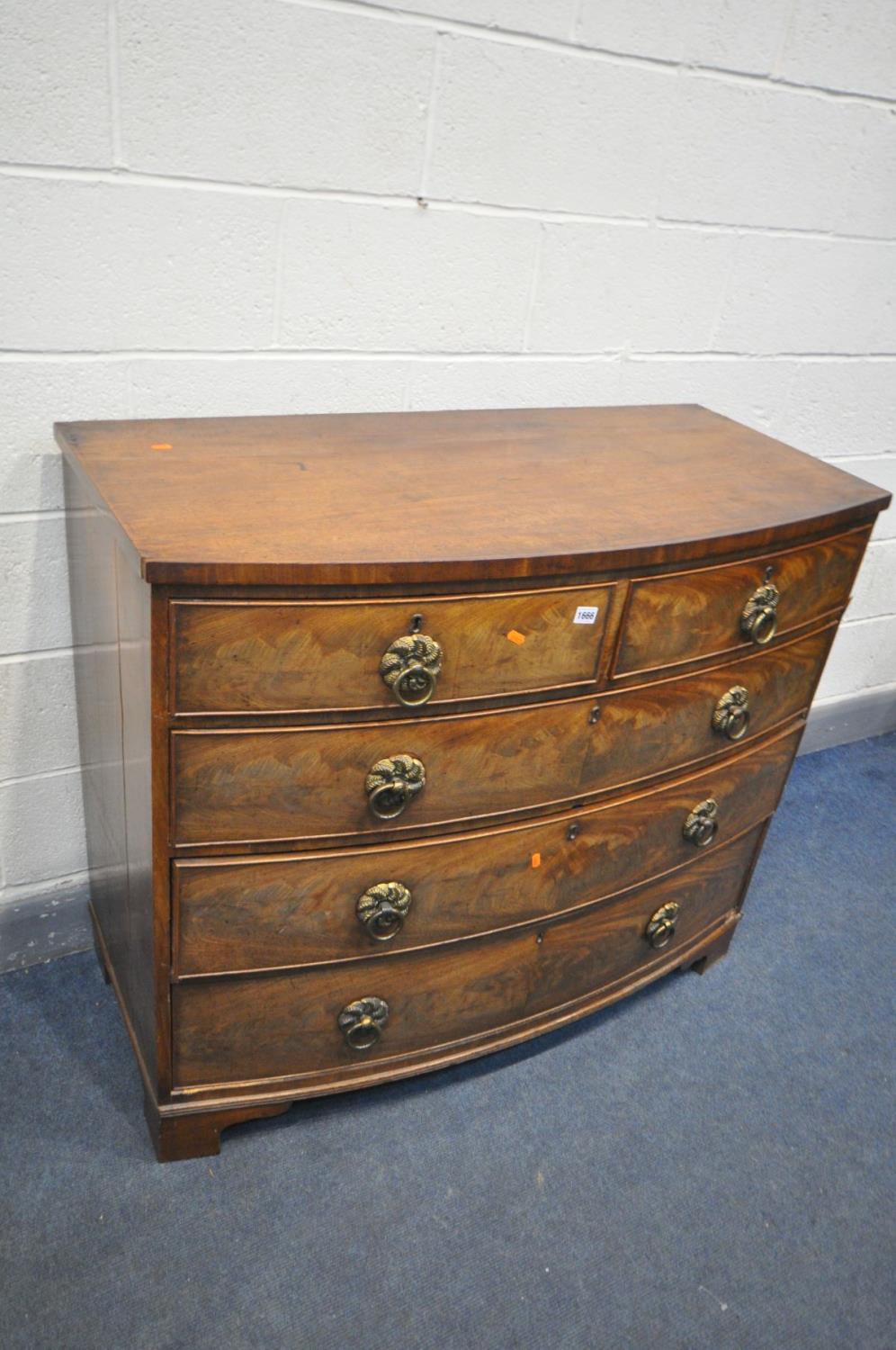 A GEORGIAN FLAME MAHOGANY BOWFRONT CHEST OF TWO SHORT AND THREE LONG DRAWERS, with brass circular