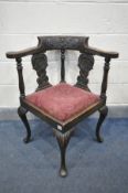 A LATE 19TH/EARLY 20TH CENTURY CARVED OAK CORNER CHAIR with a drop in seat pad