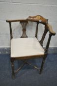 AN EDWARDIAN MAHOGANY AND INLAID CORNER CHAIR, with a shaped back rest, cream stripped upholstery,