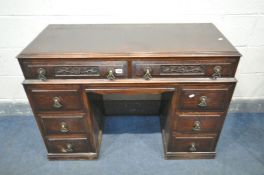 AN OAK DESK with an arrangement of eight drawers, width 112cm x depth 46cm x height 80cm