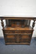 A LATE 20TH CENTURY OAK COURT CUPBOARD, with single upper door, flanked by two carved supports, base