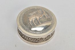 AN INDIAN WHITE METAL BOX, the circular box with scroll and floral embossed detail and fitted lid,