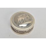 AN INDIAN WHITE METAL BOX, the circular box with scroll and floral embossed detail and fitted lid,