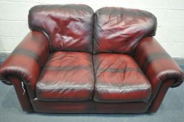 AN OXBLOOD LEATHER TWO SEATER SETTEE, length 152cm x depth 97cm x height 75cm