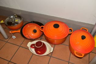 A GROUP OF LE CREUSET CAST IRON COOKWARES, to include an oval casserole dish, a large circular