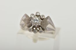A WHITE METAL DIAMOND RING, abstract bow style ring set centrally with a round brilliant cut