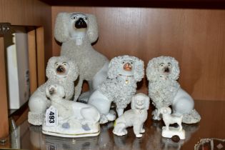 SIX VICTORIAN STAFFORDSHIRE WHITE GLAZED AND FRIT DECORATED POODLE FIGURES AND A SIMILAR SMALL