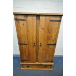 A SOLID PINE DOUBLE DOOR WARDROBE, with iron hinges and handles, and a single long drawer, width