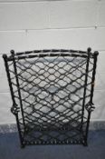 A WROUGHT IRON WINE RACK, with four ball finials on barley twist supports and open twisted sections,