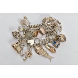 A WHITE METAL CHARM BRACELET, comprising approximately twenty plus various charms to include a fish,
