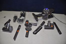 A DYSON DC85 cordless vacuum with charger and accessories including wall mount