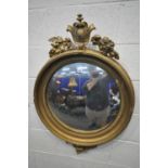A REGENCY GILTWOOD CONVEX WALL MIRROR, the surmount with Lobed leaves and acorns surrounding a