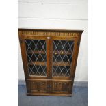 A LATE 20TH CENTURY OAK LEAD GLAZED TWO DOOR BOOKCASE, with two small cupboard doors, width 97cm x