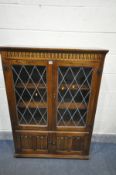 A LATE 20TH CENTURY OAK LEAD GLAZED TWO DOOR BOOKCASE, with two small cupboard doors, width 97cm x