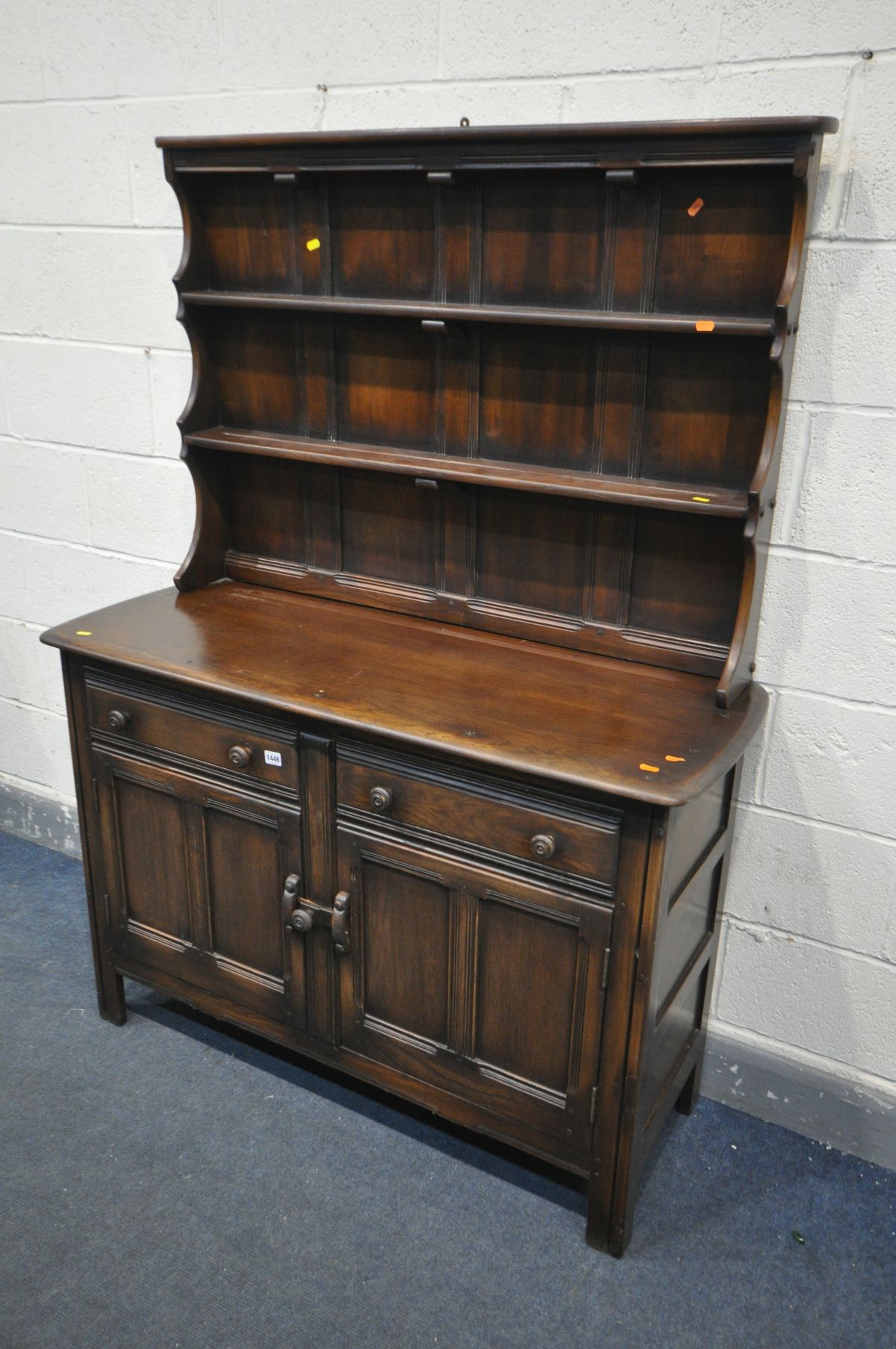 AN ERCOL OLD COLONIAL ELM DRESSER, length 123cm x depth 48cm x height 166cm x height of base 85cm, a