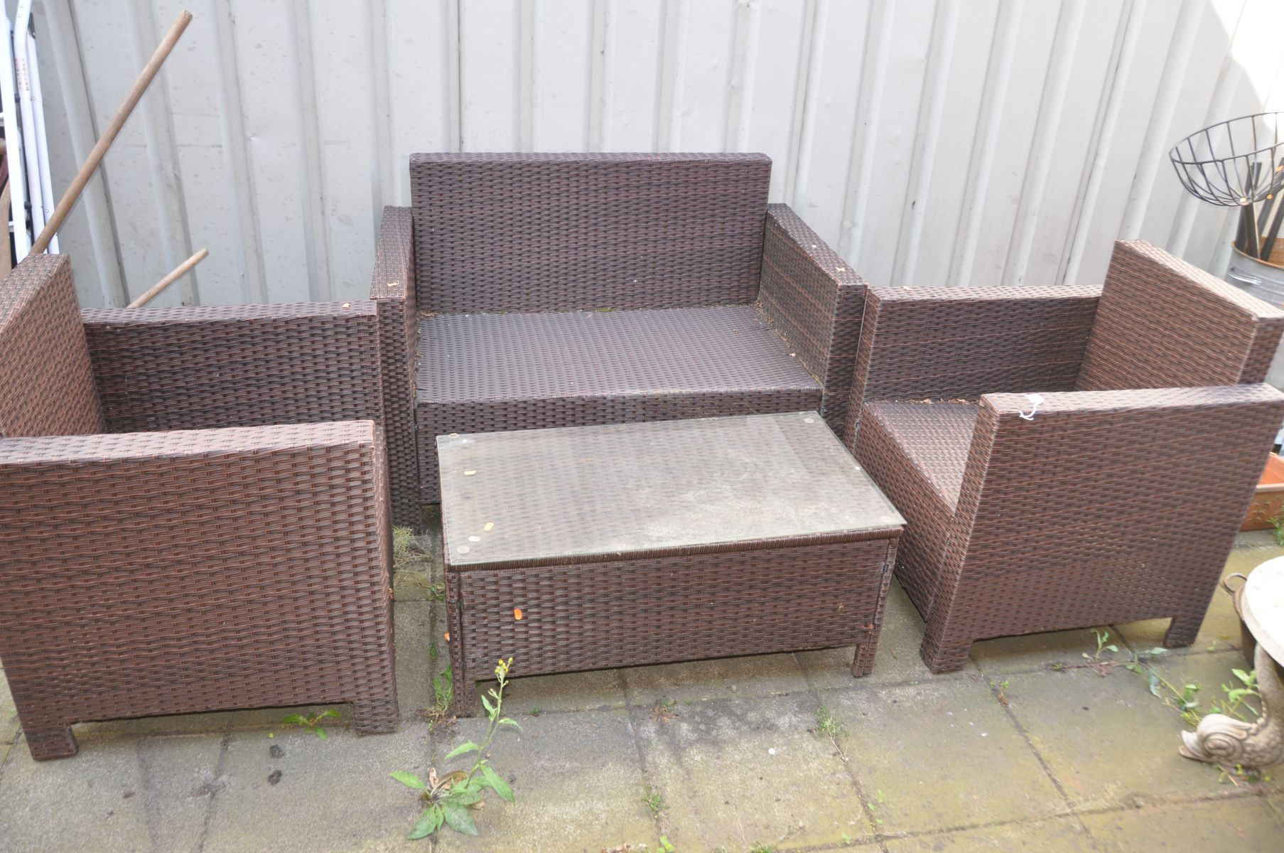 A RATTAN EFFECT GARDEN SET, comprising a two seater bench, pair of armchairs and a coffee table with