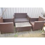 A RATTAN EFFECT GARDEN SET, comprising a two seater bench, pair of armchairs and a coffee table with