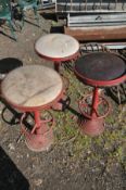 THREE ART DECO RED PAINTED METAL HIGH STOOLS, with a circular top, and footrest, on a stepped