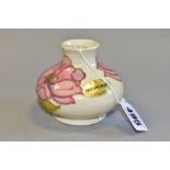 A MOORCROFT POTTERY SQUAT VASE DECORATED WITH PINK HIBISCUS, on a cream ground, gold factory sticker