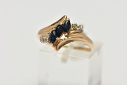 A YELLOW METAL SAPPHIRE AND DIAMOND DRESS RING, of crossover design, set with three marquise cut