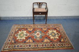 AN EDWARDIAN MAHOGANY PIANO STOOL, and a Turkish Kazak rug, 84cm x 111cm (2)