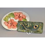 A MOORCROFT PEACOCK FEATHERS RECTANGULAR TRAY AND A MOORCROFT CORAL HIBISCUS OVAL TRAY, the former