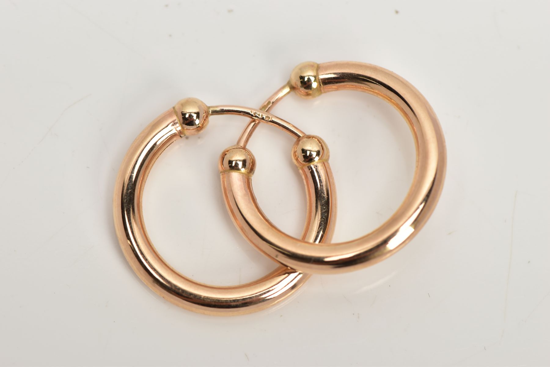 A PAIR OF 9CT GOLD EARRINGS, each hollow ear hoop of plain polished design with spherical bead