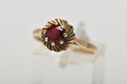 A 9CT YELLOW GOLD GARNET SINGLE STONE RING, set with a circular cut garnet, within a textured