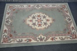 A ORIGIN CHINESE GREEN RUG, 180cm x 119cm and a pink upholstered armchair (2)