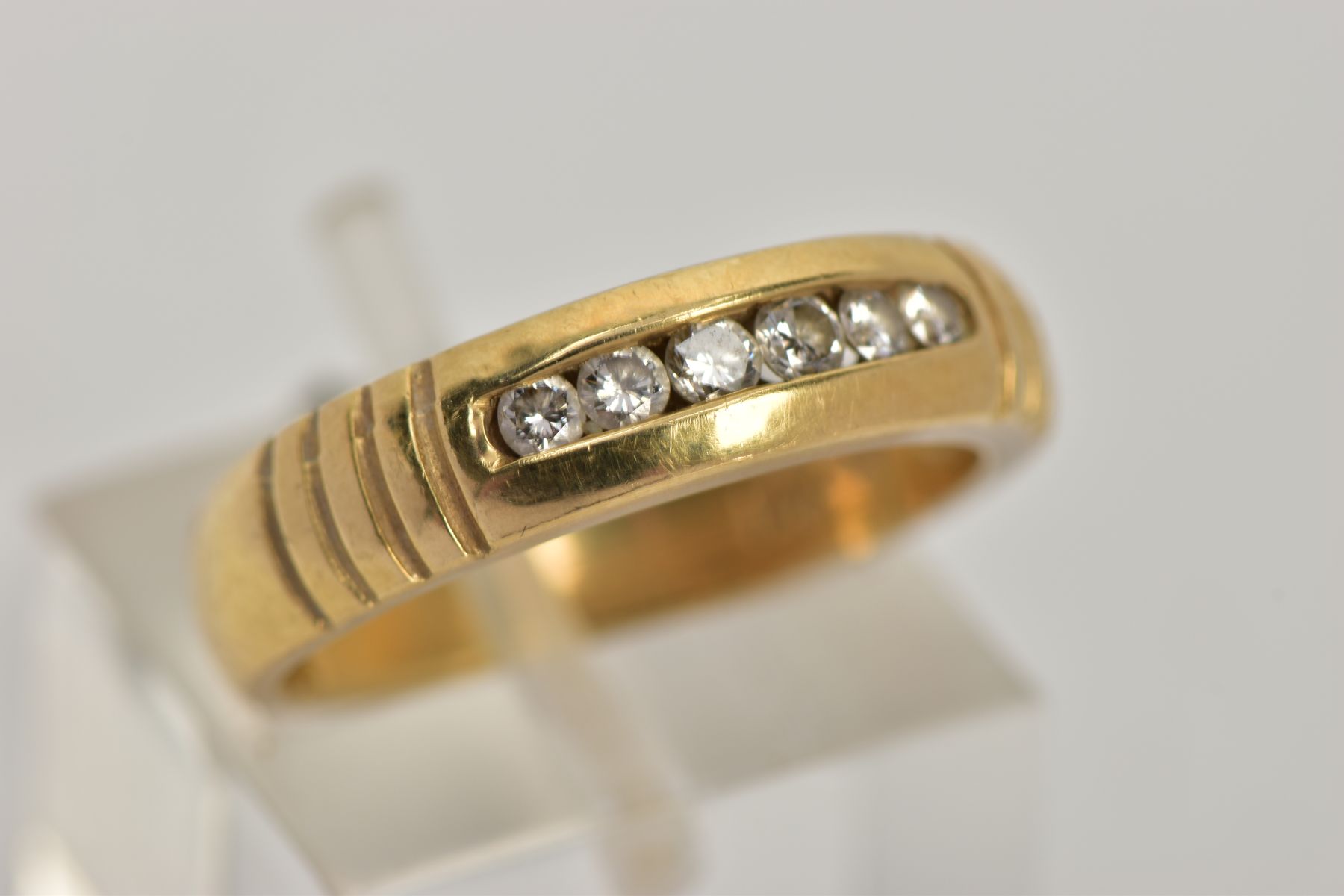 A YELLOW METAL DIAMOND RING, wide band measuring approximately 4.7mm, designed with a row of channel - Image 4 of 4