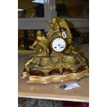 A GILT FIGURAL MANTEL CLOCK, featuring a female kneeling figure and an angel, surrounded by