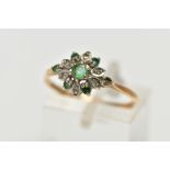 A 9CT YELLOW GOLD EMERALD AND DIAMOND CLUSTER RING, set with a circular cut emerald, within an