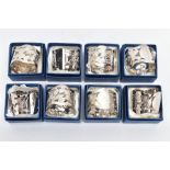 A SET OF EIGHT SILVER NAPKIN RINGS, each designed with a pierced foliate motif with undulating