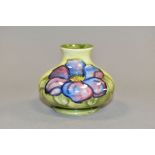 A MOORCROFT POTTERY SQUAT BALUSTER VASE DECORATED WITH PUPLE CLEMATIS ON A SHADED GREEN GROUND,