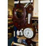 A MAHOGANY WALL MIRROR WITH SHELF AND A BAROMETER, the wall mirror having oval bevelled glass set in