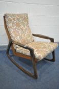 A MID-CENTURY TEAK ROCKING CHAIR, with shaped armrests, and floral cushions, width 66cm x depth 86cm