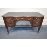 AN EARLY 20TH CENTURY VICTORIAN STYLE MAHOGANY DESK, with a black leather writing surface, and seven