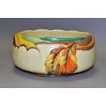 A CLARICE CLIFF AUTUMN LEAF FRUIT BOWL, with moulded, painted leaf design on a cream ground,