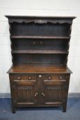 A REPRODUCTION OAK LINENFOLD DRESSER, with two drawers, width 115cm x depth 46cm x height 182cm x