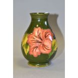 A MOORCROFT POTTERY BALUSTER VASE DECORATED WITH CORAL HIBISCUS, on a green ground, impressed