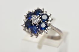 A SAPPHIRE AND DIAMOND CLUSTER RING, set with a principal round brilliant-cut diamond, surrounded by